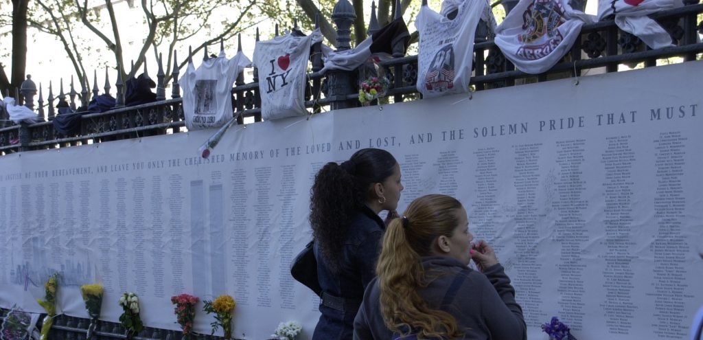 New York, NY, 12 Settembre, 2002 - Persone da ogni parte del mondo si fermano a leggere i nomi delle vittime al Ground Zero